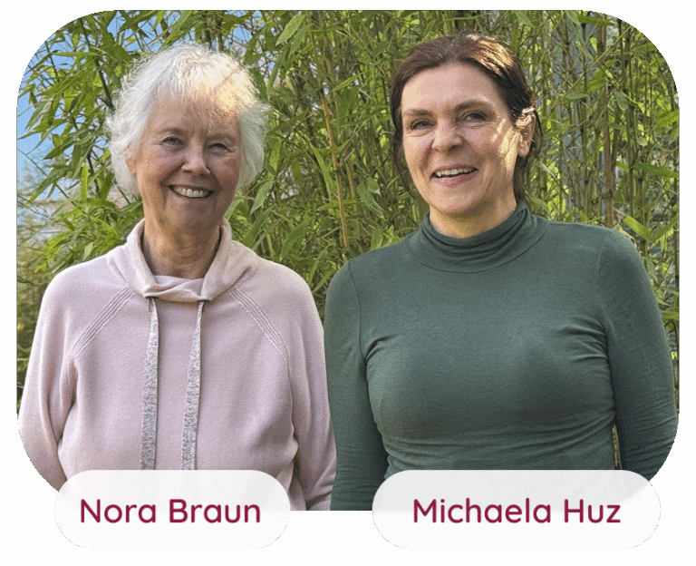 Die Yogalehrerinnen Nora Braun und Michaela Huz lachen entspannt vor einem Bambusstrauch im Garten.